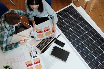 Green energy engineer helping client to figure out how many solar panels she needs for her house