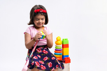 Indian little girl playing with the Rubik's cube.
