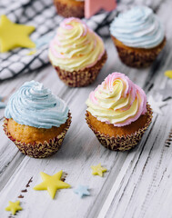Delicious cupcakes with colorful cream on wood table