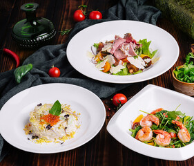 different salads in white plates on a wooden table