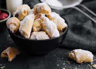 Homemade fresh cookies dusted powdered sugar in black plate