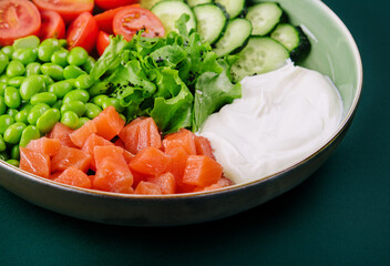 Poke bowl with salmon, cucumber, tomato, rice and edamame beans