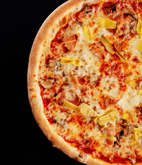 italian pizza with sliced ham and artichokes on black background