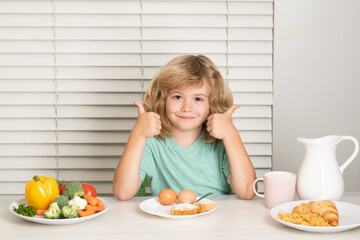 Kid boy eating healthy food vegetables. Breakfast with milk, fruits and vegetables. Child eating during lunch or dinner.