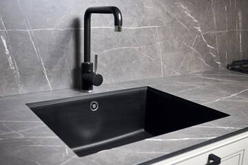 Kitchen sink area with black square matte sink tap in contemporary style. Matte black and stoneware...