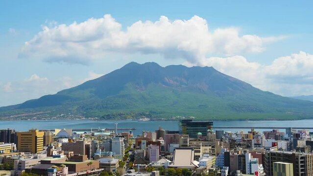 Time lapse over Kagoshima city of Sakurajima volcano with billowing white clouds