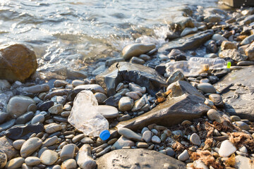plastic pollution of Black sea. old crumpled bottle on coast. environmental protection