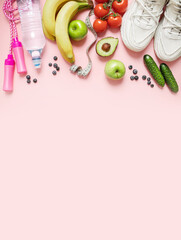 Obraz na płótnie Canvas stylish layout. healthy lifestyle and weight loss concept. fresh vegetables and fruits, a bottle of water, a measuring tape, sneakers and a skipping rope on a pink pastel background. flat lay. 