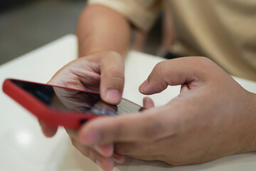 Relaxed young asian man using smart phone  spending time checking news social media.