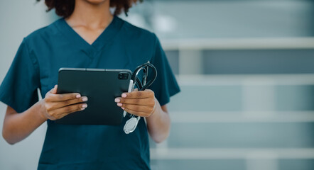African American female doctor using digital tablet at hospital, Healthcare professional and medical concepts.