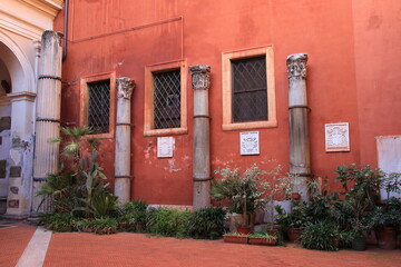 Fototapeta na wymiar San Silvestro in Capite Church Courtyard with Red Wall and Ancient Columns in Rome, Italy