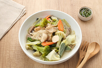 Capcay, stir fried vegetables with shrimp, meatballs and chicken. Served in white plate
