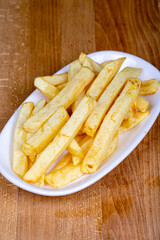 Fried potatoes or potato chips. Hand peeled french fries in a ceramic bowl. close up