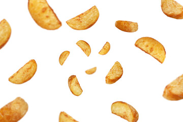 Falling fried Potato wedges, isolated on white background, selective focus