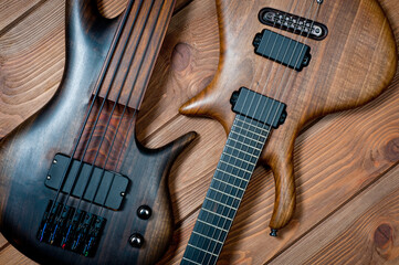 Fototapeta premium Electric rhythm guitar and five-string bass photographed on a wooden surface.