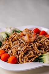 wok fried fu Zhou braised ee fu noodle bee hoon longevity noodle mee with seafood mushroom prawn egg meat and vegetables on wood table asian chinese halal food menu for restaurant