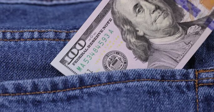 take cash American hundred dollar bills lying in the pocket of jeans, American dollars close-up