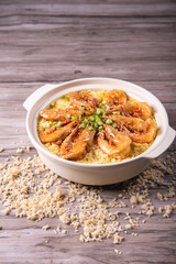 poached fried jasmine rice with giant tiger sea prawn and green bean vegetable in yellow golden chicken stock cheesy sauce in claypot on wood table asian chinese halal food seafood menu for restaurant