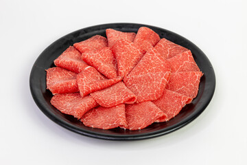 Wagyu beef slices in black plate on white background