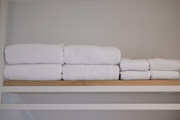 Clean white towel on wood shelf prepared to use in bathroom at hotel.