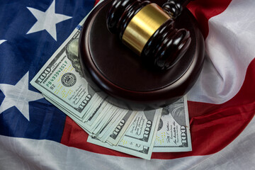 hundred dollar bills and a judge's gavel placed on an American flag.