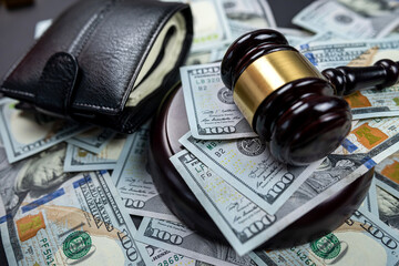 Judicial wooden gavel of a man in a robe on the background of dollars money isolated.