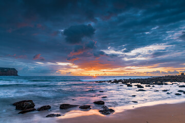 Naklejka premium Sunrise with scattered rain clouds at the seaside