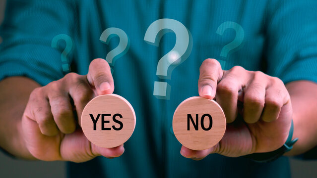 Man holding two wooden with yes or no word on it and making decision with question mark.