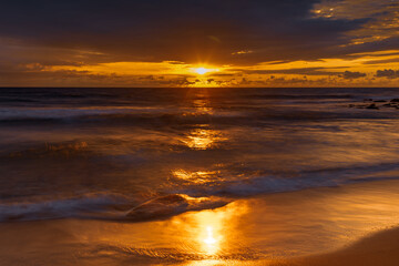 Fototapeta na wymiar Sunrise with scattered rain clouds at the seaside
