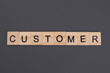 Customer word from wooden blocks on gray background