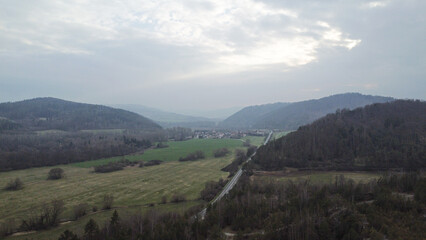 Fototapeta na wymiar aerial shot of scenic wild nature. Forests, fields, meadows. mountains in the distance in a haze. 
