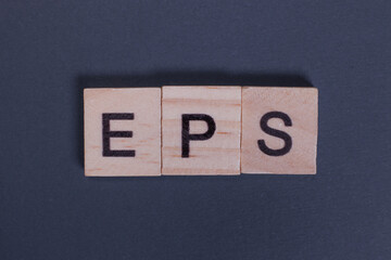 EPS earnings per share from wooden letters on a gray background