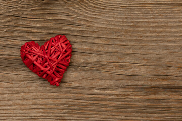 red heart on rustic brown wooden background with free space for text