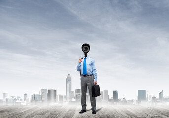 Camera headed man standing on wooden floor against modern cityscape