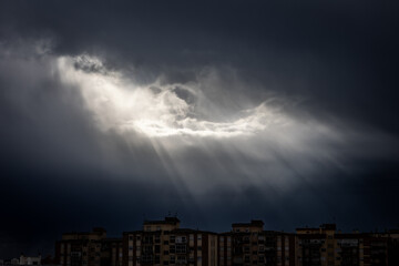 Obraz premium sun rays and storm over the city