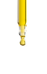 Dropper pipette with yellow oil drop on the whte isolated background Close up.Copy space