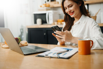 Young beautiful woman using laptop and tablet while sitting at her working place. Concentrated at work. in office..