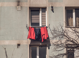Old worn out communist apartment building in Bucharest, Romania. Old clothes laundry left to dry on the balcony.