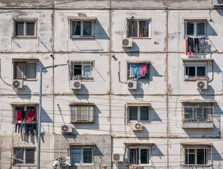 Worn out apartment building from the communist era against blue sky in Bucharest Romania. Ugly...