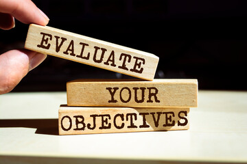 Wooden blocks with words 'EVALUATE YOUR OBJECTIVES'.