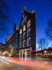 Obraz premium A thin house. Amsterdam, Netherlands. View of houses during sunset. The famous Dutch view. A cityscape in the evening. Travel photography.