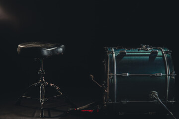 Fototapeta na wymiar Bass drum and chair on a black background, drummer's seat.