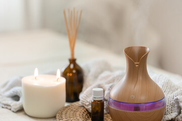 Spa composition with aroma oil diffuser lamp on a blurred background.