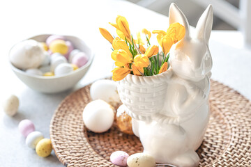 Easter still life with a ceramic hare, eggs and flowers.