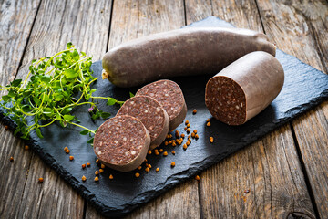 Raw buckwheat pudding on black stone cutting board on wooden table
