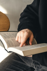 Open book Bible in male hands, close-up.