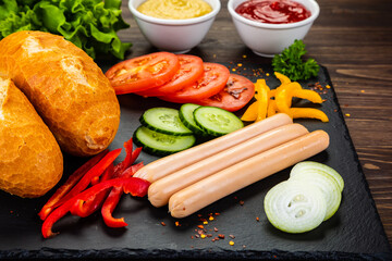 Hot dog ingredients on stone black plate
