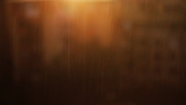 Orange texture with falling rain. Rain drops in front of blurred orange background.