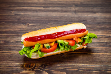 Hot dog with ketchup on wooden table 
