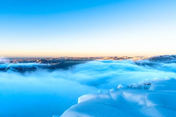 Naklejka na ściany i meble Beautiful landscape of clouds covering the snowy mountains
